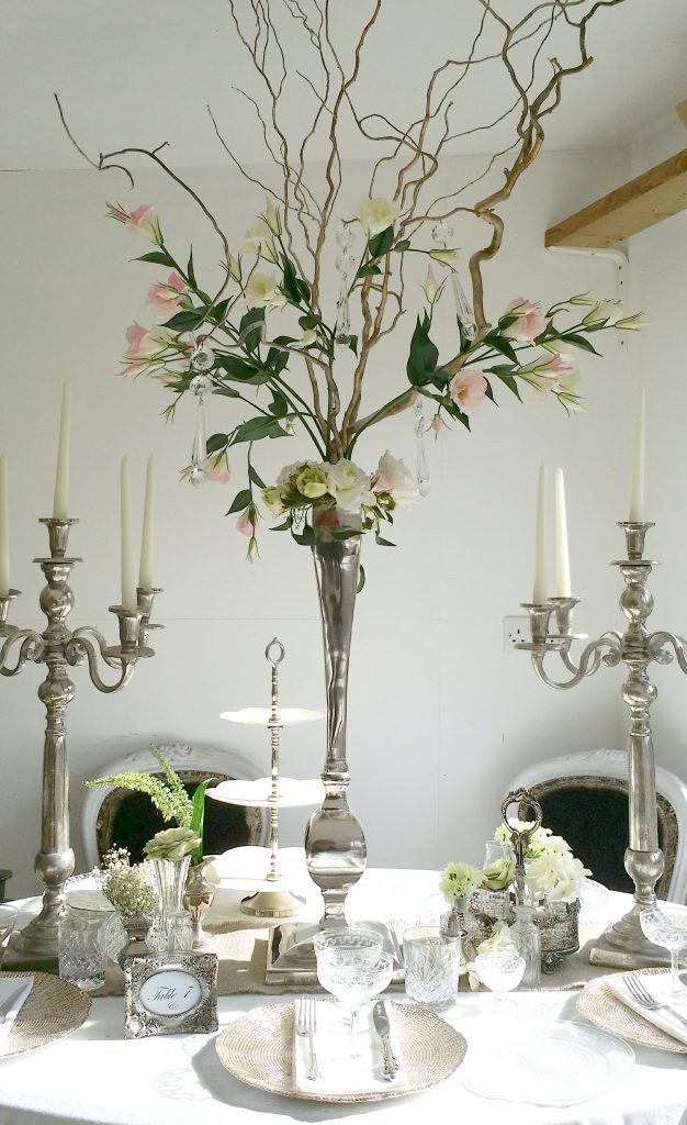 tall wedding table centerpiece with tall silver candelabras, vintage glasses and gold charger plates