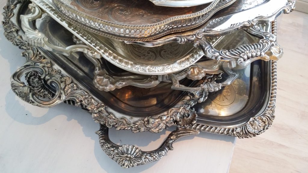 A stack of ornate silver vintage trays oval round and rectangle all available to hire