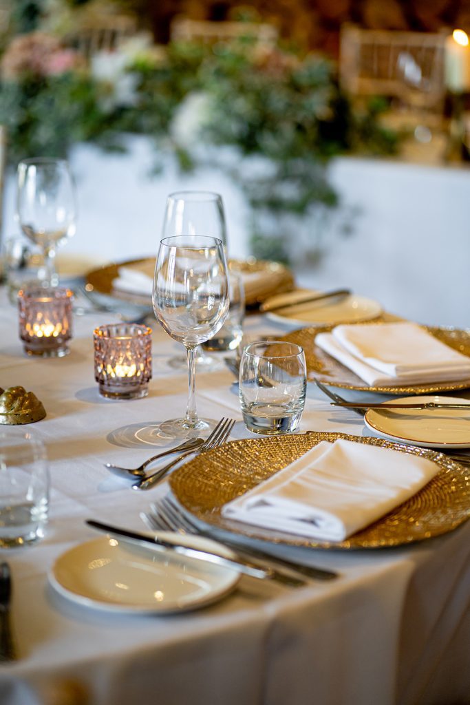 A table set up showing off our gold foil charger plates and pink tealight holders