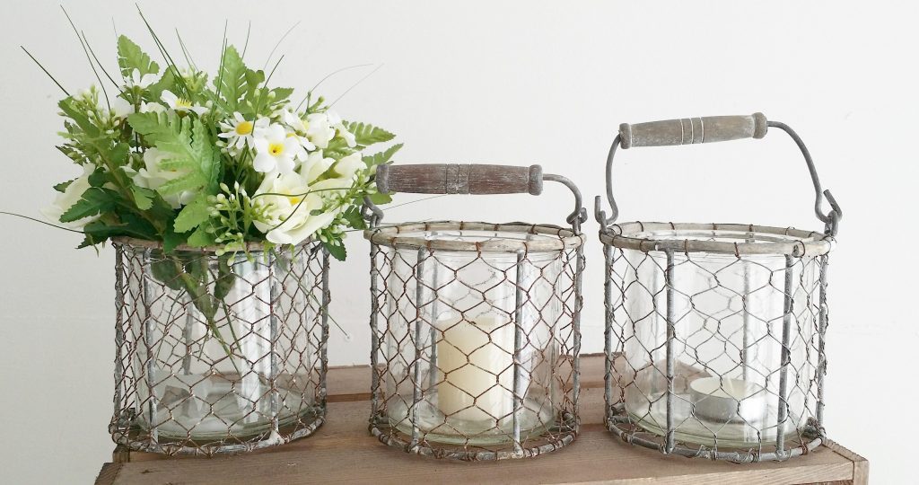 hire rustic chicken wire candle or flower holders with a glass vase and wooden handle for woodland props available for hire for weddings and events