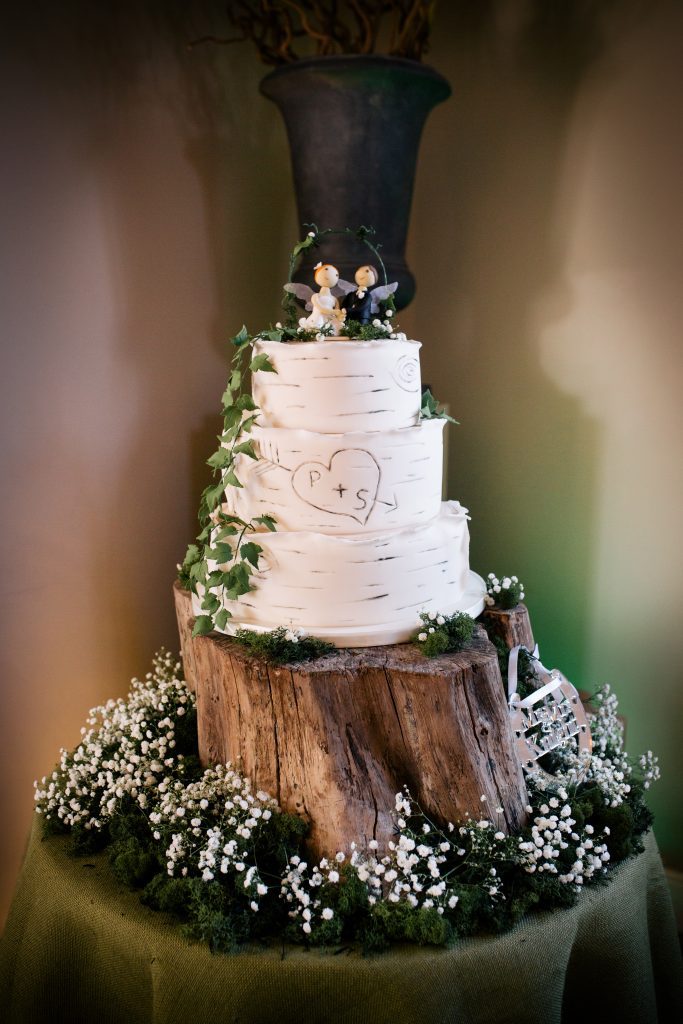 Wooden tree trunk for wedding cake surrounded by moss an gypsophila